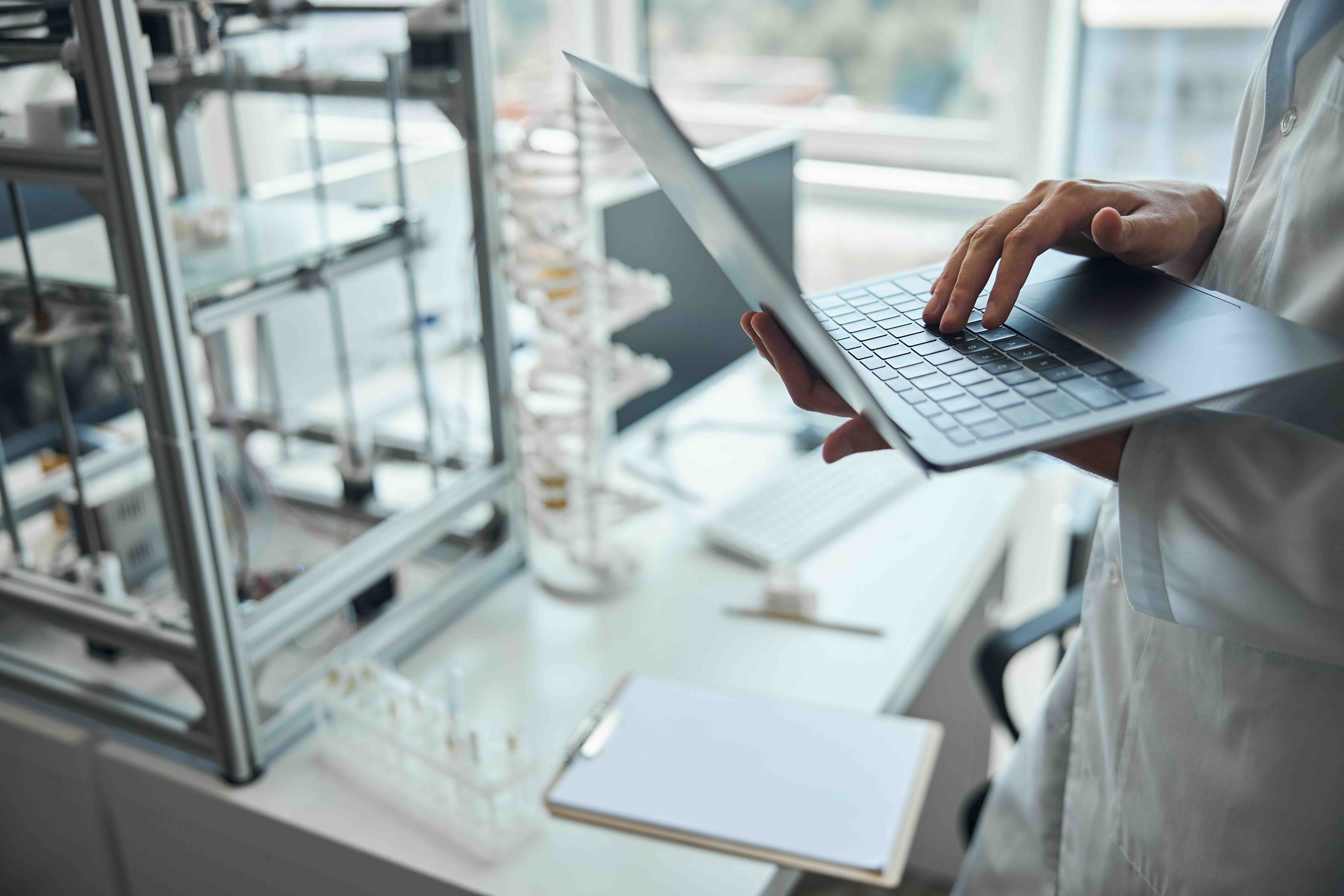 A scientist analyzing data on a laptop inside a core research facility, representing how QReserve tracks high-value asset utilization rates to provide VPR offices with real-time institutional ROI analytics.